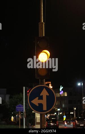 Ampel mit gelber Ampel, Straßenschild links abbiegen und Schieß los. in der Stadt. Stockfoto