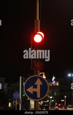 Ampel mit roter Ampel für Stopp, Straßenschild links abbiegen und Schieß los. in der Stadt. Stockfoto