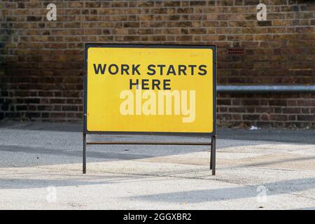 Die Arbeit beginnt hier Straßenarbeiter unterschreiben Stockfoto