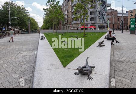 Amsterdam, Niederlande - 15. August 2021: Dreieckiges grünes Feld mit einer großen Anzahl von comodo-Drachen oder Eidechsen, Bronzestatuen, die herumkrabbeln. Straße Stockfoto
