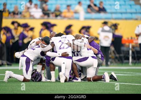 Charlotte, North Carolina, USA. September 2021. Spieler von East Carolina Pirates teilen sich vor dem Start des Duke's Mayo Classic 2021 zwischen Appalachian State und East Carolina im Bank of America Stadium in Charlotte, North Carolina, eine Hingabe. Rusty Jones/Cal Sport Media/Alamy Live News Stockfoto