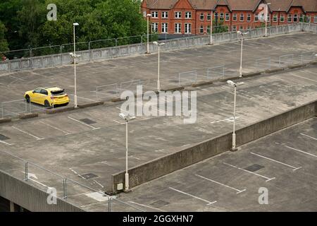 Ein fast leerer Parkplatz in Birmingham. Ein einstöckiges, hellgelbes Auto im obersten Stock. Stockfoto