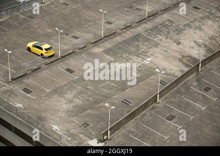 Ein fast leerer Parkplatz in Birmingham. Ein einstöckiges, hellgelbes Auto im obersten Stock. Stockfoto