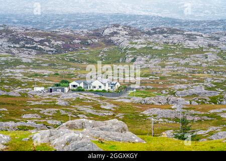 Blick auf ein einsames Haus inmitten einer felsigen kargen Landschaft an den Buchten an der Ostküste von Isle of Harris, Äußere Hebriden, Schottland, Großbritannien Stockfoto