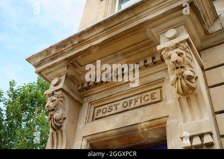 Eine alte Eingangstür oder ein Portikus der Post. Eine große Steinfassade mit geschnitzten Steinlöwen. Ein königlicher und wichtiger Ort zu gehen. Stockfoto