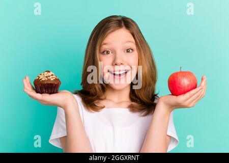 Foto Porträt Mädchen Skalierung süß Cupcake Apfel lächelnd glücklich isoliert hell blaugrün Farbe Hintergrund Stockfoto