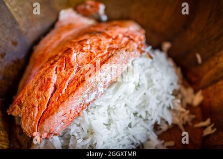 Gegrillter gekochter roter Sockeye-Lachs, Meeresfrüchte, Fischfilet aus der Nähe auf weißem Reisbett und Holzschüssel Stockfoto