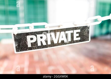 Makro-Nahaufnahme von privaten Immobilien Immobilien schwarz und weiß Zeichen hängen an Kette vor Haus Haus Veranda Eingang in Key West, Florida Stockfoto