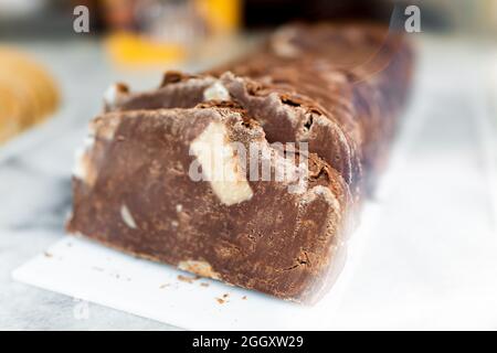 Makro-Nahaufnahme von Milch oder dunkler Schokolade hausgemachten Fudge-Scheiben in Süßwarenladen im Einzelhandel mit Stücken von weißem Kakao Stockfoto