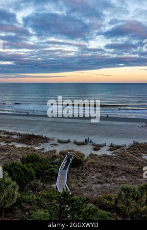 Myrtle Beach City mit Blick aus der Luft auf den Atlantik bei bewölktem, dramatischem Sonnenuntergang mit Strandzugang durch Sanddünen und Stockfoto