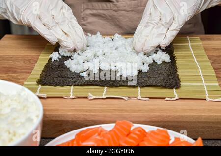 Der Prozess der Herstellung von Sushi und Brötchen, Draufsicht, Reis für Sushi. Stockfoto