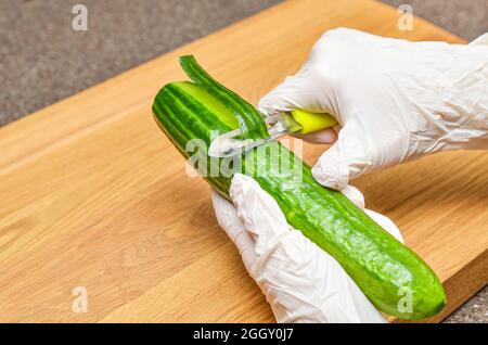 Gurkenschälen, gesunder Lebensstil und Diät-Konzept Stockfoto