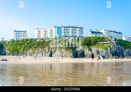 Farbenfrohe Gebäude auf der Landzunge über dem South Beach bei Tenby in Wales bei Ebbe. Stockfoto