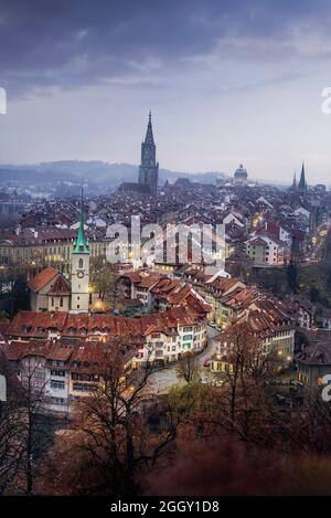 Beleuchtete Ansicht der Berner Altstadt bei Sonnenuntergang mit dem Berner Münster und der Nydeggkirche - Bern, Schweiz Stockfoto