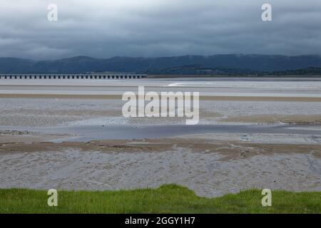 Die Leven Tidal Bohrung nähert sich dem Leven Viadukt mit der Küsteneisenbahn, vom Canal Foot in der Nähe von Ulverston aus gesehen Stockfoto