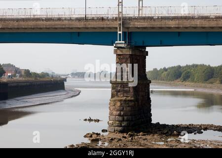 Die Lune Tidal-Bohrung nähert sich der Brücke, die die Haupteisenbahn der Westküste über die Lune-Mündung in Lancaster führt Stockfoto