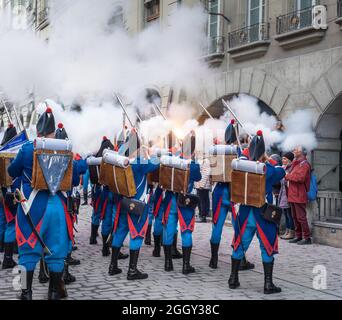 Rauch von Feuerschüssen von schweizer Soldaten auf Tracht während einer Parade auf dem Zibelemarit Holiday (Zwiebelmarkt) - Bern, Schweiz Stockfoto