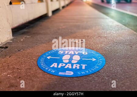 Miami Beach, USA - 18. Januar 2021: Low-Angle-Ansicht für blaues Warnschild zur Aufrechterhaltung der sozialen Distanzierung während des Covid-19-Coronavirus-Ausbruchs Stockfoto