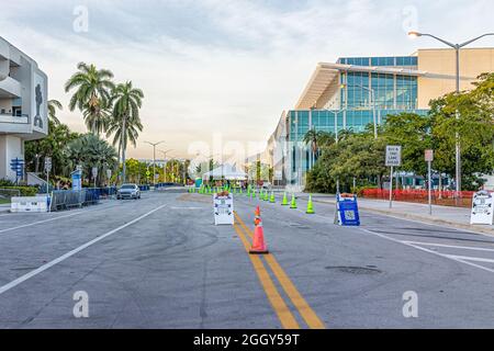 Miami Beach, USA - 21. Januar 2021: Oraler PCR-Test auf Covid-19-Coronavirus mit Menschen, die an der Teststelle an einer geschlossenen Straße mit Schild Schlange stehen Stockfoto