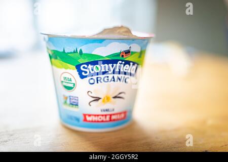 Herndon, USA - 25. März 2021: Closeup Pack Behälter aus Bio-Vollmilch glatte und cremige Vanille Stonyfield Joghurt Joghurt auf Holztisch Stockfoto