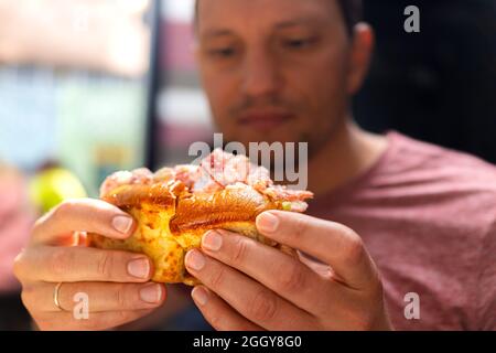 Junger Mann hält in den Händen klassisches Maine Hummerroll Sandwich in Brioche-Brötchen in Meeresfrüchte-Restaurant Café in Key West, Florida Stockfoto