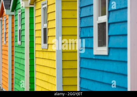 Eine Reihe von kleinen bunt bemalten Hütten oder Schuppen aus Holz. Die lebhaften Außenwände sind farbenfroh. Stockfoto