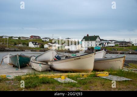 Twillingate, NL, Kanada-August 2021: Die kleine Fischergemeinde Twillingate, Neufundland, mit kleinen weißen Fischerbooten auf einer Holzrutsche. Stockfoto