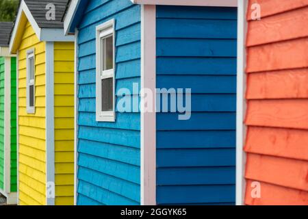 Eine Reihe von kleinen bunt bemalten Hütten oder Schuppen aus Holz. Die lebhaften Außenwände sind farbenfroh. Stockfoto