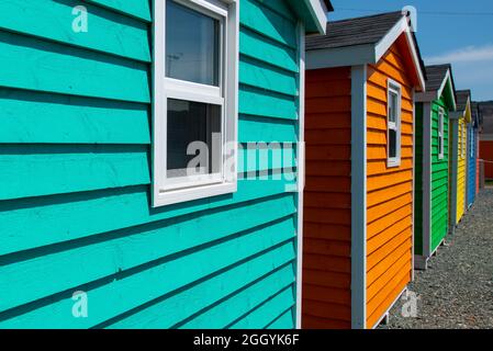 Eine Reihe von kleinen bunt bemalten Hütten oder Schuppen aus Holz. Die lebhaften Außenwände sind farbenfroh. Stockfoto