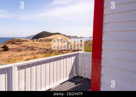 Das Äußere eines alten weißen Holzgebäudes ist mit einem schmalen weißen Cape Cod-Klappbrett mit leuchtend roten Holzverkleidungen bedeckt. Stockfoto