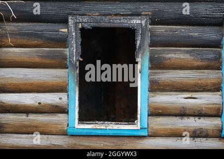 Holzhaus nach dem Feuer. Kohlen auf den Protokollen. Die Asche des Hauses aus dem Feuer. Verbrannte zerstörte Hütte. Stockfoto