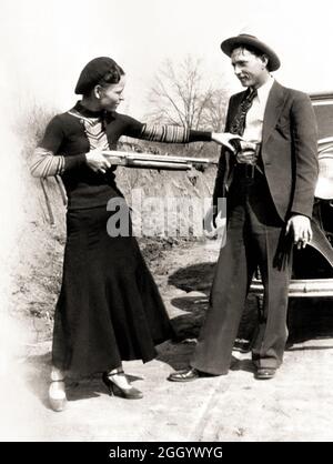 1934 , Arkansas , USA : die berühmten Gangsterne BONNIE PARKER ( 1910 - 1934 ) und CLYDE BARROW ( 1909 - 1934 ). Entgegen der landläufigen Meinung haben die beiden nie geheiratet. Sie waren in einer langjährigen Beziehung. Vor einem Ford V8-Automobil von 1932 posiert, wo Bonnie und Clyde am 23. Mai 1934 starben. Unbekannter Fotograf. - OUTLAWS - KILLER - ASSASSINO - delinquente - criminalità organizzata - GANGSTERN - Bos - CRONAKA NERA - CRIMINALE - Auto - Automobil - Hut - cappello - fucile - arma - Gewehr - Gewehr - Schuhe - Scarpe --- Archivio GBB Stockfoto