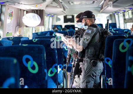 Ost-Jerusalem, Israel. September 2021. Bewaffnete israelische Streitkräfte Soldaten der Grenzkontrolleinheit, die die Beschränkungen des öffentlichen Verkehrs Covid-19 in Ostjerusalem durchsetzen. Geldstrafen für diejenigen, die keine Maske tragen. Laut den Busfahrern ist dies in den letzten Wochen ein lockeres Ereignis in den palästinensischen Gebieten der Stadt. Palästina / Israel, Jerusalem. September 2021. Kredit: Matan Golan/Alamy Live Nachrichten Stockfoto