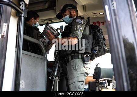 Ost-Jerusalem, Israel. September 2021. Bewaffnete israelische Streitkräfte Soldaten der Grenzkontrolleinheit, die die Beschränkungen des öffentlichen Verkehrs Covid-19 in Ostjerusalem durchsetzen. Geldstrafen für diejenigen, die keine Maske tragen. Laut den Busfahrern ist dies in den letzten Wochen ein lockeres Ereignis in den palästinensischen Gebieten der Stadt. Palästina / Israel, Jerusalem. September 2021. Kredit: Matan Golan/Alamy Live Nachrichten Stockfoto