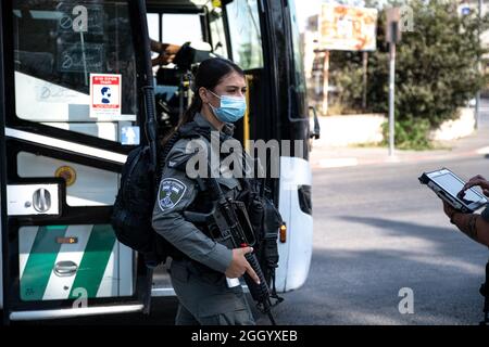 Ost-Jerusalem, Israel. September 2021. Bewaffnete israelische Streitkräfte Soldaten der Grenzkontrolleinheit, die die Beschränkungen des öffentlichen Verkehrs Covid-19 in Ostjerusalem durchsetzen. Geldstrafen für diejenigen, die keine Maske tragen. Laut den Busfahrern ist dies in den letzten Wochen ein lockeres Ereignis in den palästinensischen Gebieten der Stadt. Palästina / Israel, Jerusalem. September 2021. Kredit: Matan Golan/Alamy Live Nachrichten Stockfoto