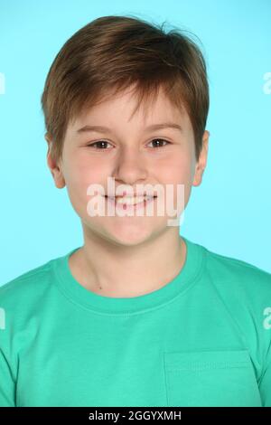 Das Porträt zeigt eine Nahaufnahme des Gesichts eines hübschen, fröhlichen Jungen. Er schaut Auge in Auge und lächelt. Stockfoto