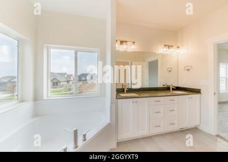 Modernes Master-Badezimmer mit weißen Schiebefenstern Stockfoto