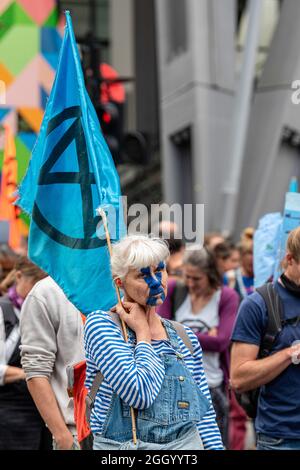 London, Großbritannien. September 2021. Eine Protesterin, deren Gesicht bemalt ist, hält während des Extinction Rebellions „Flood Money“-Protestes am 13. Tag der Impossible Rebellion eine XR-Flagge, bei dem sie sich auf Überschwemmungen, Wasser und das Meer konzentrierten. Kredit: SOPA Images Limited/Alamy Live Nachrichten Stockfoto