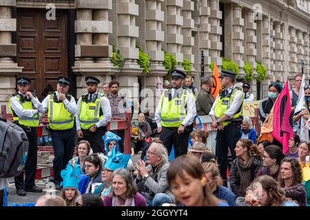 London, Großbritannien. September 2021. Die Polizei beobachtet Demonstranten, die während des Aussterbens vor dem europäischen Hauptquartier von BlackRock sitzen Rebellions „Hochwassergeld“-Protest am 13. Tag des Impossible Rebellion, bei dem sie sich auf Überschwemmungen, Wasser und das Meer konzentrierten. Kredit: SOPA Images Limited/Alamy Live Nachrichten Stockfoto