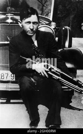 1934 , USA : Clyde Barrow mit einem Gewehr . Das berühmte Gangsterpaar BONNIE PARKER ( 1910 - 1934 ) und CLYDE BARROW ( 1909 - 1934 ). Entgegen der landläufigen Meinung haben die beiden nie geheiratet. Sie waren in einer langjährigen Beziehung. Vor einem Ford V8-Automobil von 1932 posiert, wo Bonnie und Clyde am 23. Mai 1934 starben. Unbekannter Fotograf .- OUTLAWS - KILLER - ASSASSINO - delinquente - criminalità organizzata - GANGSTERN - Bos - CRONAKA NERA - CRIMINALE --- Archivio GBB Stockfoto