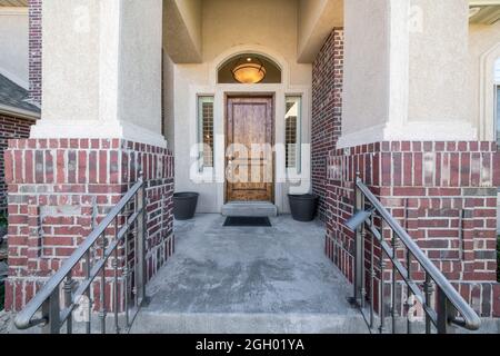 Hölzerne Eingangstür eines Hauses mit zwei Seitenverkleidungen und gewölbtem Heckfenster Stockfoto