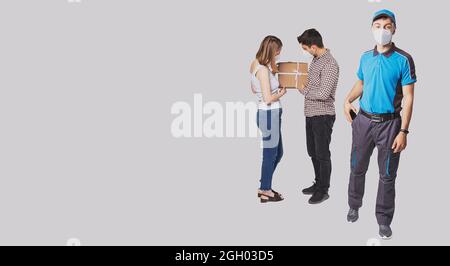 Das Seitenkopie-Weltraumfoto eines Paares erhielt das Paket und sie schauten es an, der Postbote steckte das Handy in die Tasche, alles in einer medizinischen Maske Stockfoto