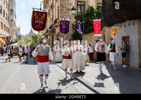 Valencia, Spanien. September 2021. Bei einer Parade in Valencia tragen Falleros, die Masken tragen, die Prämierflaggen. Las Fallas, das berühmteste Fest in Valencia, wird vom 1. Bis 5. September gefeiert, mit Einschränkungen aufgrund der COVID-19-Pandemie. Kredit: SOPA Images Limited/Alamy Live Nachrichten Stockfoto