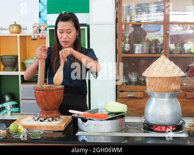 Asiatische Frau trägt Schürze, Kochen in der Küche. Stockfoto