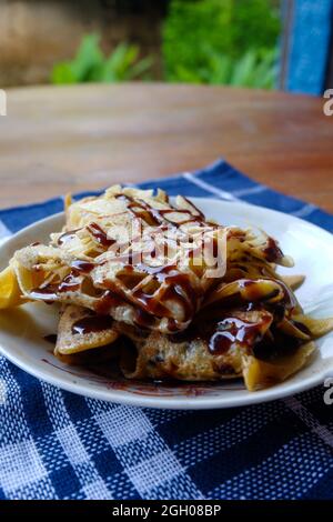 Nahaufnahme eines Brotes mit süßem Geschmack plus Schokoladensauce auf braunem Tisch in Indonesien Stockfoto