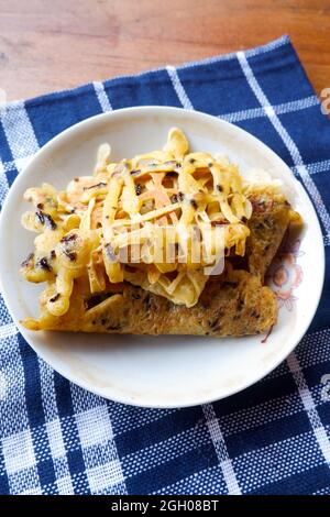 Nahaufnahme eines Brotes mit süßem Geschmack und Schokoladensauce auf dem Brauentisch in Indonesien Stockfoto