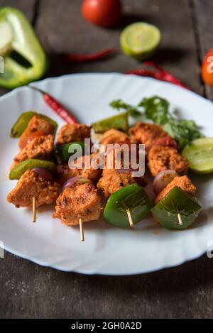 Hähnchenkebabs oder Döner, gegrillt mit sautenem Gemüse auf einem weißen Teller. Stockfoto