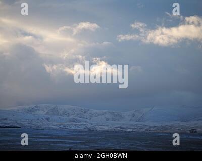 Dramatische Winterlandschaft mit brütenden Sturmwolken über der High Street und Kidsty Pike und verschneiten Shap Fells in Cumbria, England, Großbritannien Stockfoto