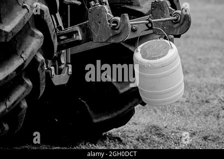 Detail einer großen Traktorräder mit hängendem Eimer. Schwarzweiß-Foto Stockfoto