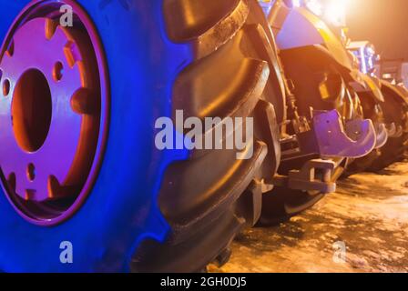 Große Gummiräder eines Traktors. Traktoren stehen in einer Reihe. Stockfoto